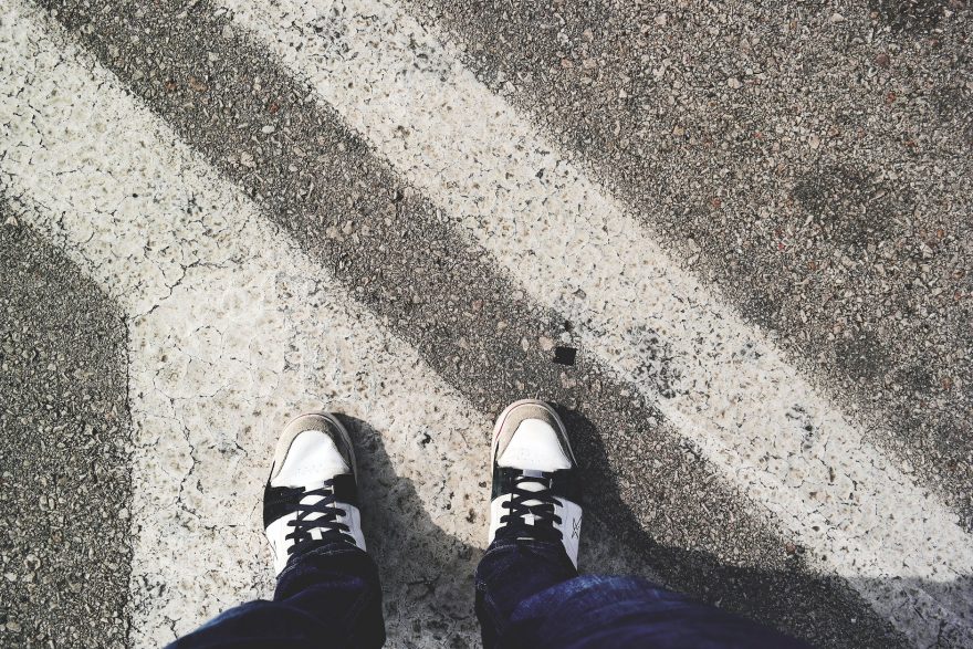man in white and black sneakers standing outdoor during daytime